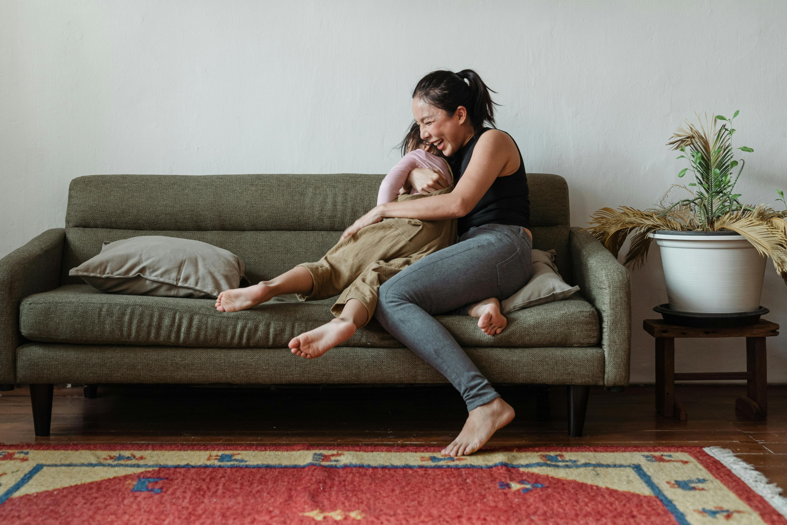 Adult comforting a child on a sofa