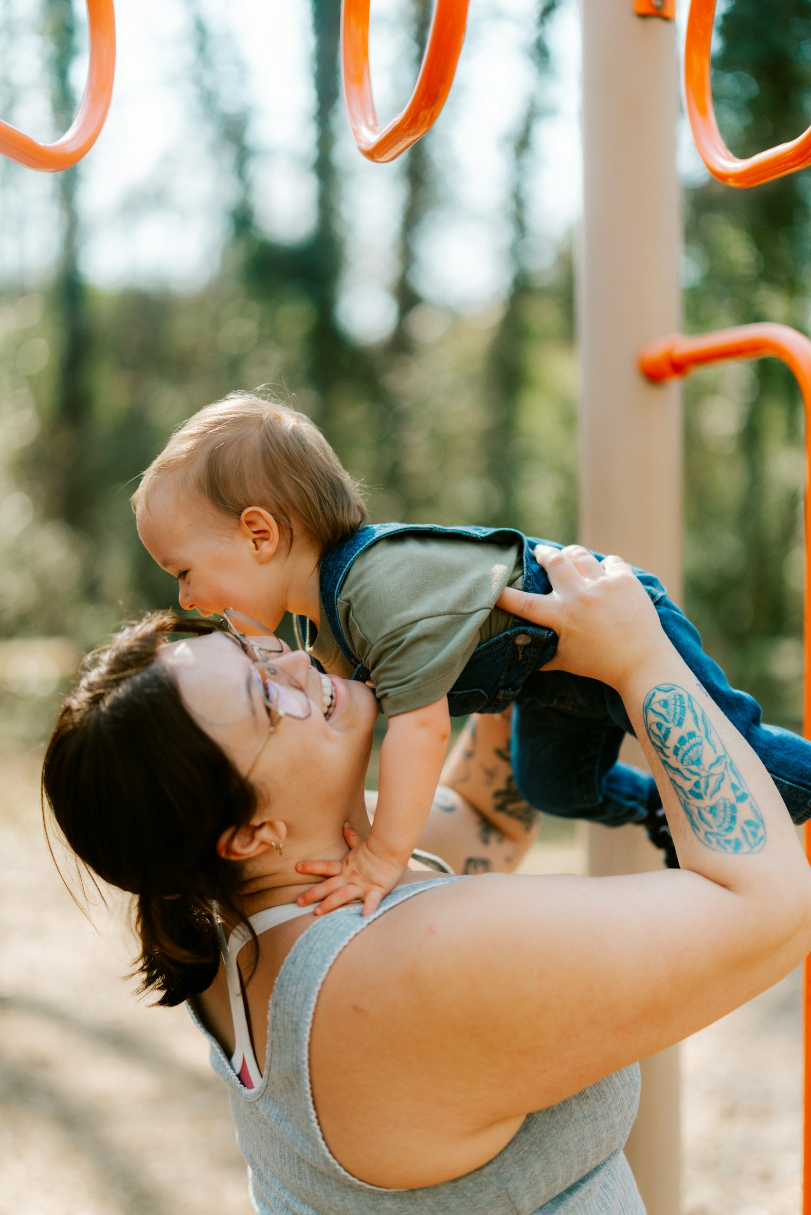 A caregiver lifting a child outdoors.